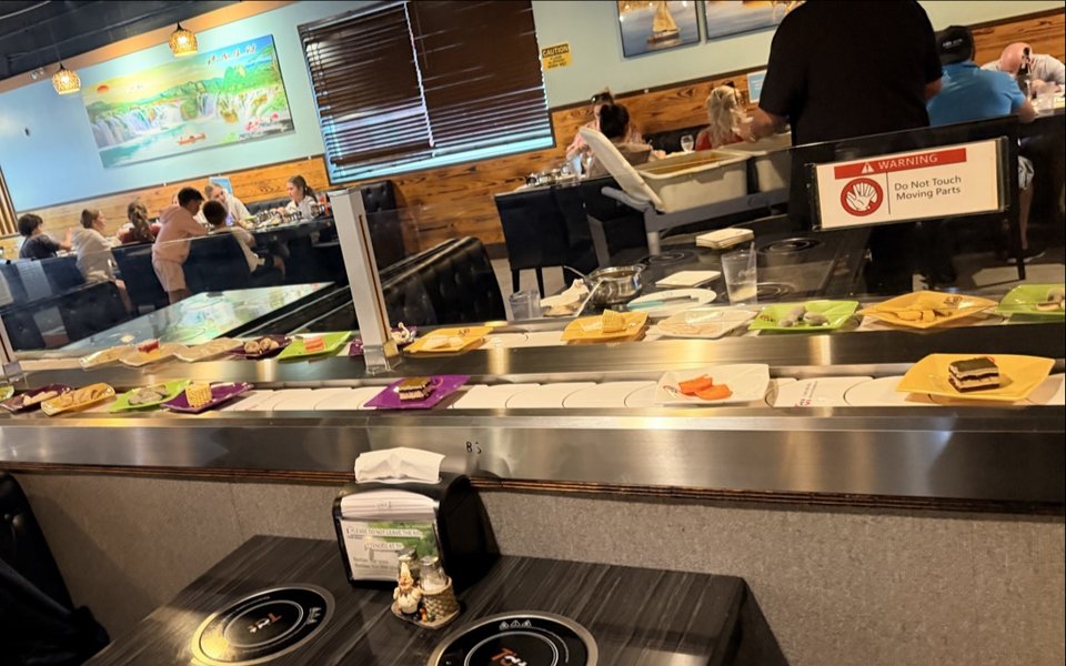 Shared table with hot pot pots and grill plates.